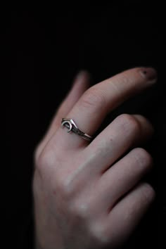 a person's hand with a ring on their left wrist, in the dark