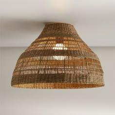 a light that is made out of wicker and hanging from the ceiling in a room