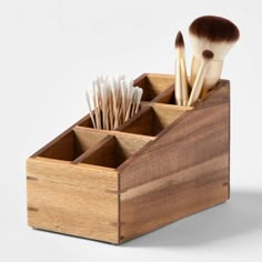 a wooden box with makeup brushes in it