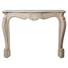 a white marble fireplace mantel with carvings on the top and bottom, in an ornate manner