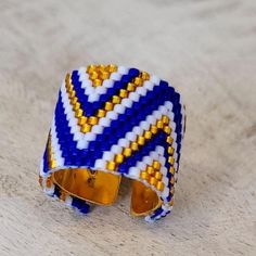 a blue and white beaded ring sitting on top of a table