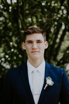 a man in a suit and tie with a boutonniere on his lapel