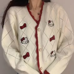 a hello kitty cardigan sweater with red bows on the front and white, cabled sleeves