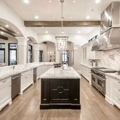 a large kitchen with white cabinets and marble counter tops