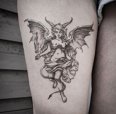 a black and white photo of a woman with a demon tattoo on her thigh,