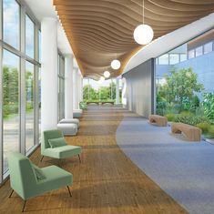 an empty hallway with green chairs and plants on the wall next to large glass windows