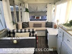 the interior of a camper with white and black decor