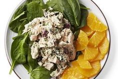 a plate with spinach, oranges and chicken salad on it's side