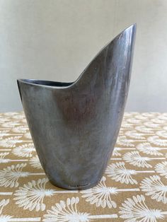 a metal vase sitting on top of a table