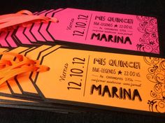 two tickets with ribbons tied to them sitting next to each other