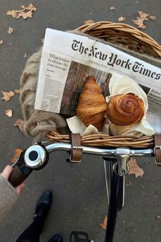 a newspaper is sitting on the back of a bicycle with croissants in it