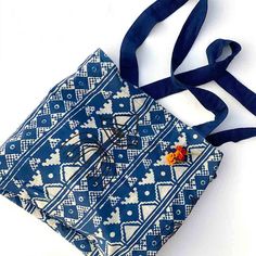 Made with recycled fabric, this bag has 3 different designs -- one on the front, one on the back, and another on the inside with an all-over indigo and white print. It's essentially 3 bags in one. The colors are a mix of coral red, indigo blue, and white. The bag dimensions are 16 x 1 x 16 inches. Blue Cotton Beach Bag For Shopping, Indigo Cotton Bag For Everyday Use, Eco-friendly Blue Cotton Beach Bag, Everyday Blue Cotton Beach Bag, Everyday Indigo Cotton Bag, Blue Cotton Tote Beach Bag, Blue Cotton Shoulder Beach Bag, Blue Cotton Tote Shoulder Bag, Bohemian Blue Canvas Bag For Everyday Use