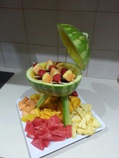 there are many different types of fruits on the table and one is cut up to look like an umbrella