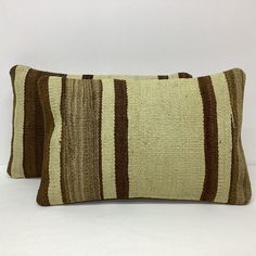 two brown and white striped pillows sitting next to each other