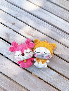 two crocheted stuffed animals sitting on top of a wooden bench