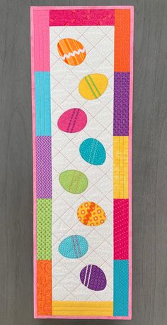 a quilted wall hanging with colorful circles on it