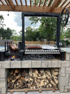 an outdoor grill with wood stacked on it