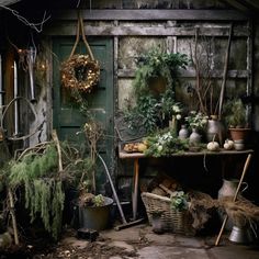 an old shed with various plants and pots on the table in front of it,