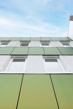 a tall building with lots of windows next to a blue sky