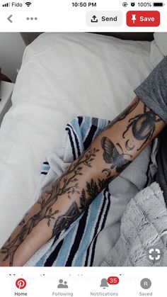 a person laying in bed with a tattoo on their arm