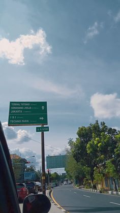 a green street sign sitting on the side of a road