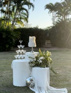 an outdoor setting with white table cloths and vases