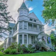 a large white house sitting on top of a lush green field