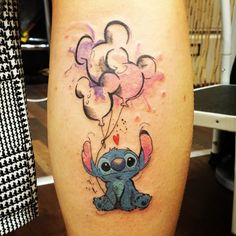 a small tattoo on the leg of a person with an elephant and balloons in the air