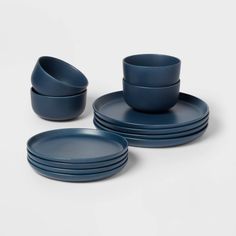 blue dishes and cups are stacked on top of each other, with one empty bowl in the middle