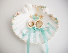 a white shell with two pairs of baby shoes on it's face and pearls around the eyes