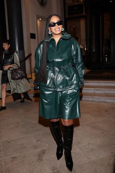 a woman in green leather outfit and black boots