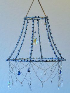 a chandelier hanging from the ceiling with blue beads and crystal drops on it