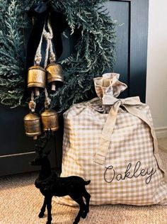 a christmas wreath with bells and a bag next to it