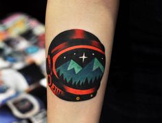 a small tattoo on the arm of a person with mountains and stars in the sky