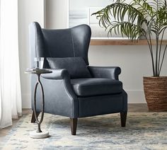 a leather recliner chair with footstool in front of a potted plant