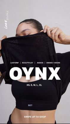 a woman holding up a black shirt with the words oynx printed on it