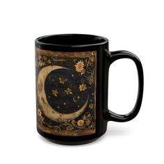 a black coffee mug with an image of the moon and stars on it's side