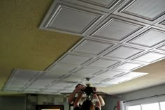 two people are taking pictures of the ceiling