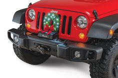 a red jeep with a christmas tree on it's front bumper and the hood