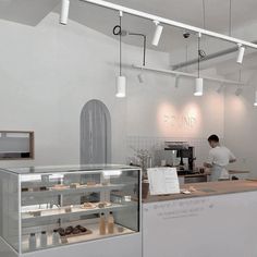 a man standing behind a counter in a bakery