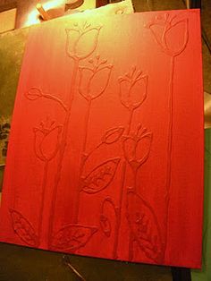 a red piece of art with flowers drawn on it and some lights in the background