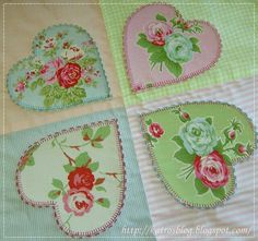 four heart shaped placemats with roses on them in pastel green, pink and blue