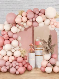 a pink and white backdrop with balloons