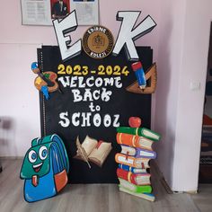 a welcome back to school sign in front of some books on the floor and posters above it