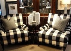 two black and white checkered couches in a room with pictures on the wall