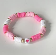 a pink and white bracelet with gold accents