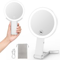 a hand is holding up a round mirror next to it's holder and accessories