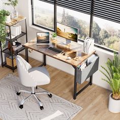 a computer desk with a laptop on top of it next to a potted plant