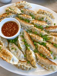 a white plate topped with dumplings covered in sauce