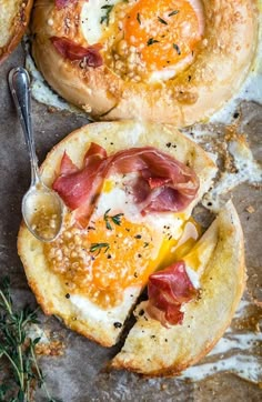 two breads with bacon and cheese on them, one has an egg in the middle